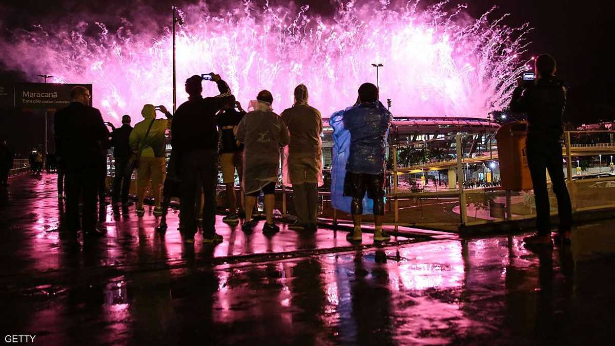 يراقبون الألعاب النارية في حفل الختام تحت المطر