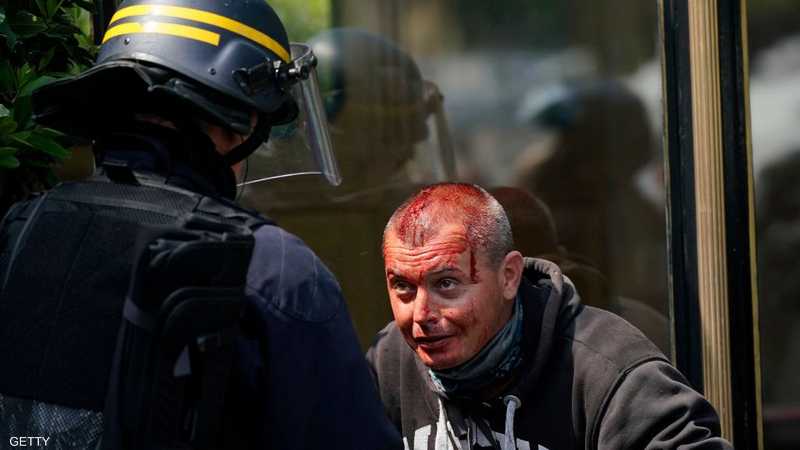 رجل أمن يحاول مساعدة متظاهر ينزف الدماء في باريس