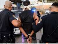 عنصران من الشرطة الإسرائيلية يقتادن زكريا الزبيدي بعد تقييده