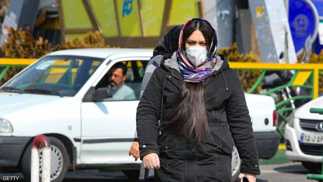 فتاة إيرانية ترتدي كمامة في أحد شوارع طهران